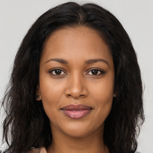 Joyful black young-adult female with long  black hair and brown eyes