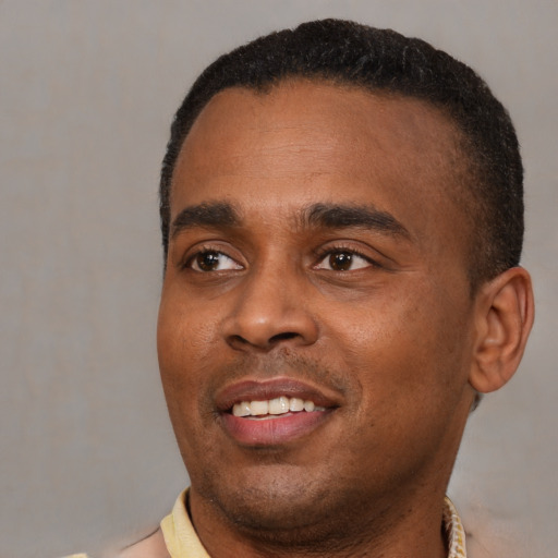Joyful black young-adult male with short  black hair and brown eyes