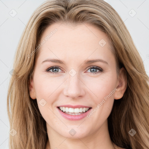 Joyful white young-adult female with long  brown hair and green eyes