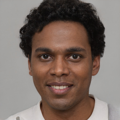 Joyful black young-adult male with short  black hair and brown eyes