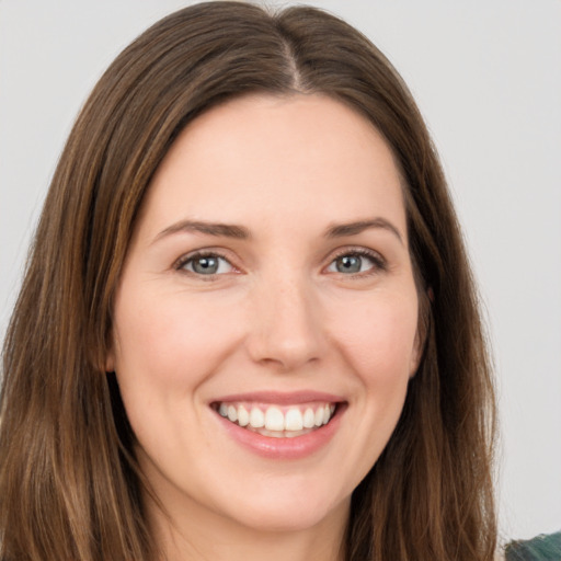 Joyful white young-adult female with long  brown hair and green eyes