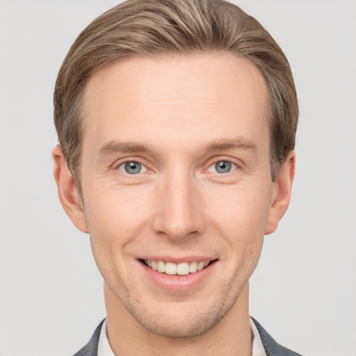 Joyful white adult male with short  brown hair and grey eyes