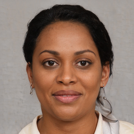 Joyful latino adult female with medium  brown hair and brown eyes