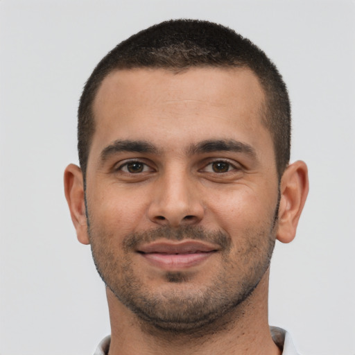 Joyful latino young-adult male with short  brown hair and brown eyes