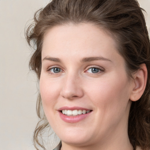 Joyful white young-adult female with medium  brown hair and green eyes