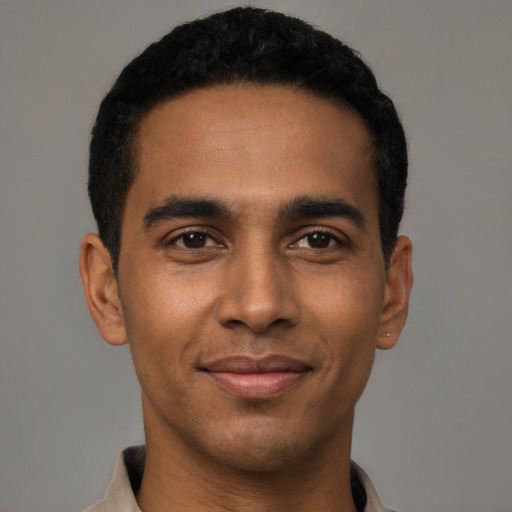 Joyful black young-adult male with short  black hair and brown eyes