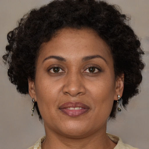 Joyful black adult female with medium  brown hair and brown eyes