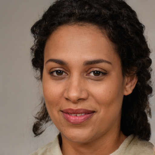 Joyful latino adult female with medium  brown hair and brown eyes