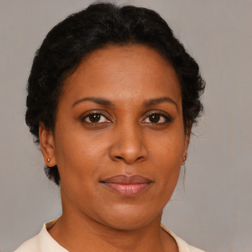 Joyful black adult female with short  brown hair and brown eyes
