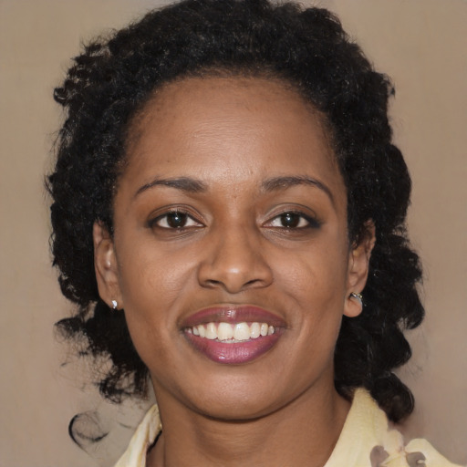 Joyful black young-adult female with long  brown hair and brown eyes