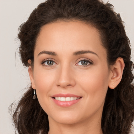 Joyful white young-adult female with long  brown hair and brown eyes