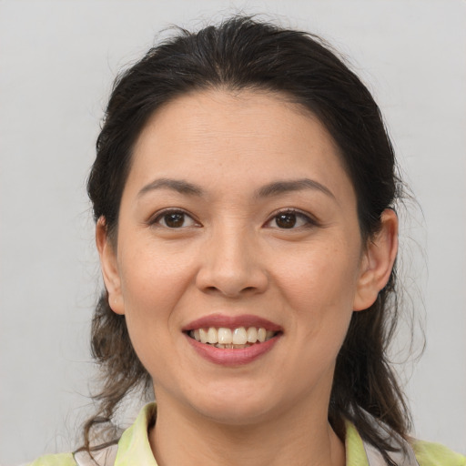 Joyful latino young-adult female with medium  brown hair and brown eyes