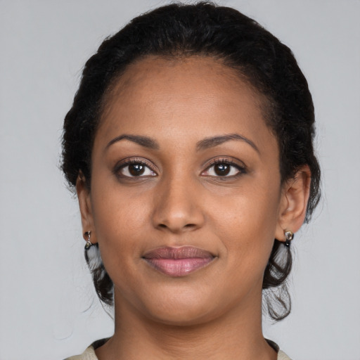 Joyful black young-adult female with long  black hair and brown eyes