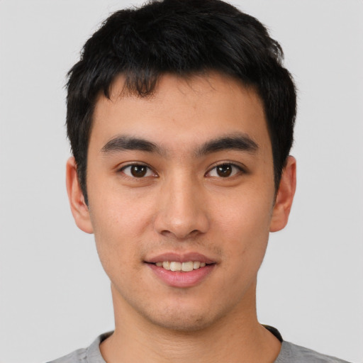 Joyful asian young-adult male with short  black hair and brown eyes