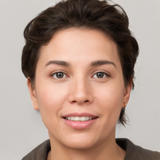 Joyful white young-adult female with short  brown hair and grey eyes