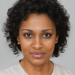 Joyful black young-adult female with medium  brown hair and brown eyes