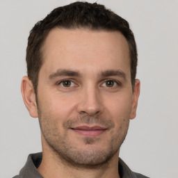 Joyful white young-adult male with short  brown hair and brown eyes