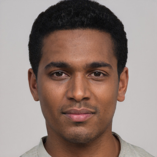 Joyful black young-adult male with short  black hair and brown eyes
