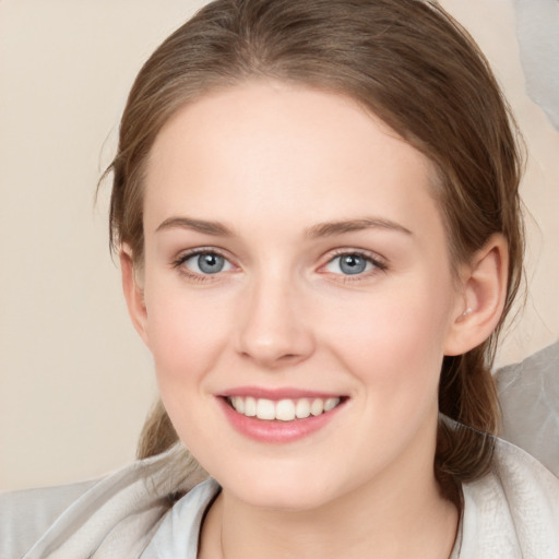 Joyful white young-adult female with medium  brown hair and grey eyes