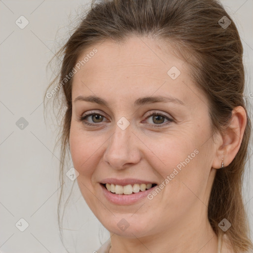 Joyful white young-adult female with medium  brown hair and grey eyes