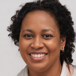 Joyful black adult female with long  brown hair and brown eyes