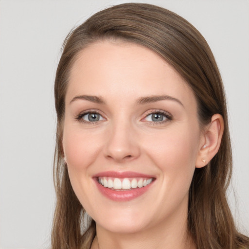 Joyful white young-adult female with long  brown hair and grey eyes