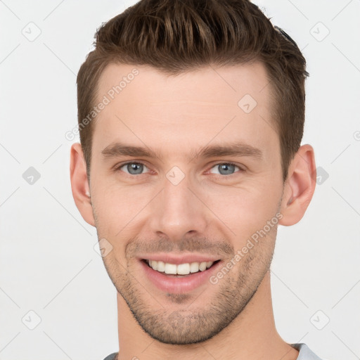 Joyful white young-adult male with short  brown hair and grey eyes