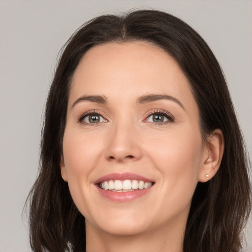 Joyful white young-adult female with long  brown hair and brown eyes