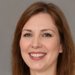 Joyful white adult female with long  brown hair and brown eyes