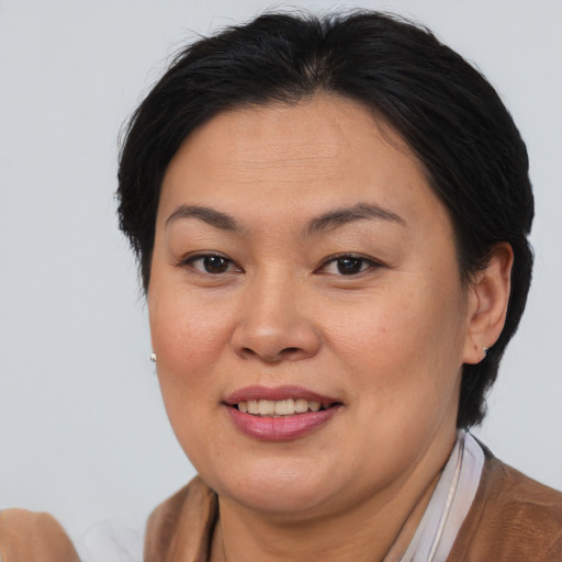 Joyful asian adult female with medium  brown hair and brown eyes
