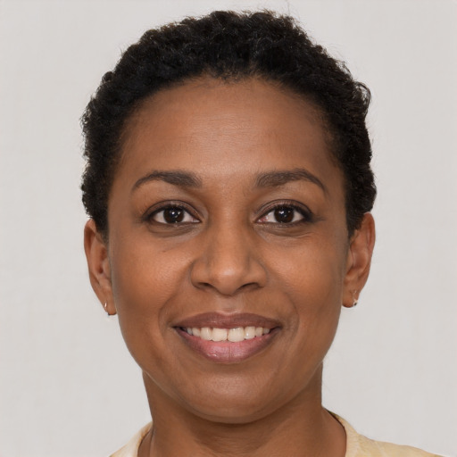 Joyful black adult female with short  brown hair and brown eyes