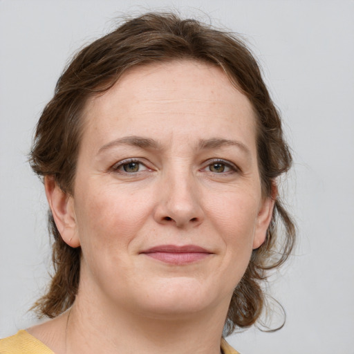 Joyful white adult female with medium  brown hair and grey eyes