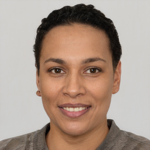 Joyful latino young-adult female with short  black hair and brown eyes