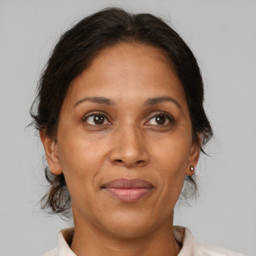 Joyful latino adult female with medium  brown hair and brown eyes