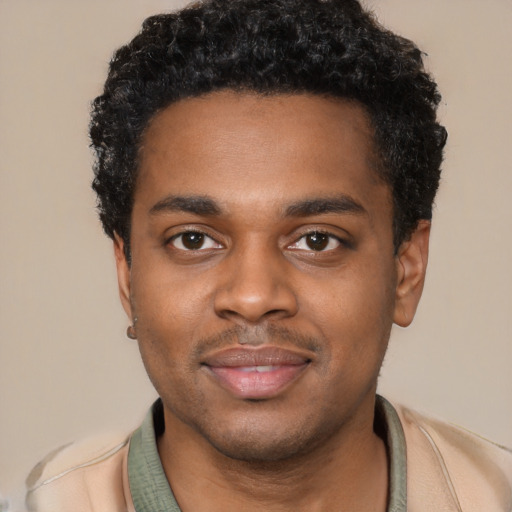 Joyful black young-adult male with short  black hair and brown eyes