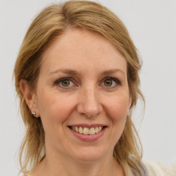 Joyful white adult female with medium  brown hair and blue eyes