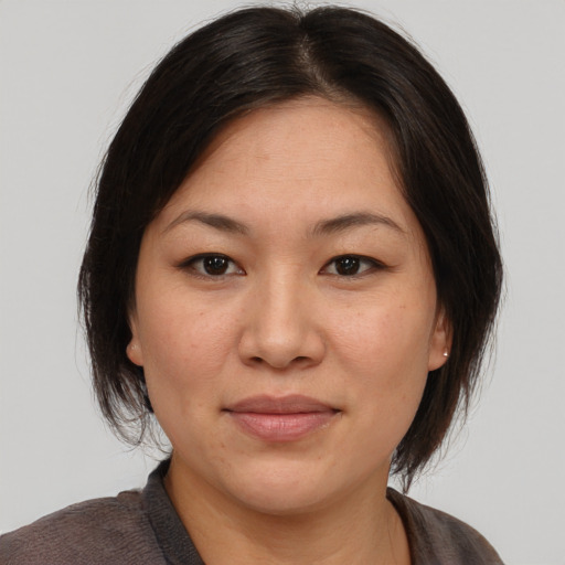 Joyful asian adult female with medium  brown hair and brown eyes