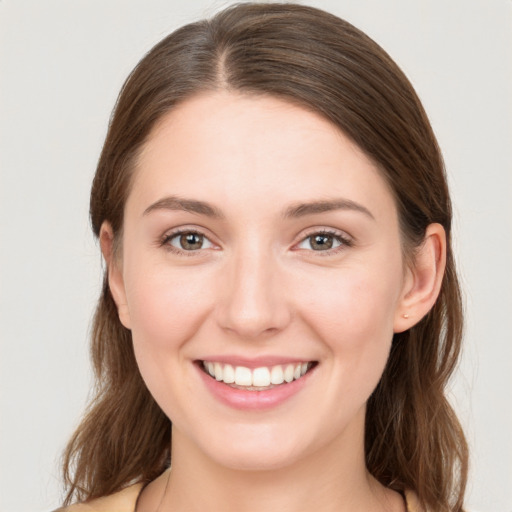 Joyful white young-adult female with medium  brown hair and grey eyes