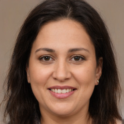 Joyful white adult female with long  brown hair and brown eyes