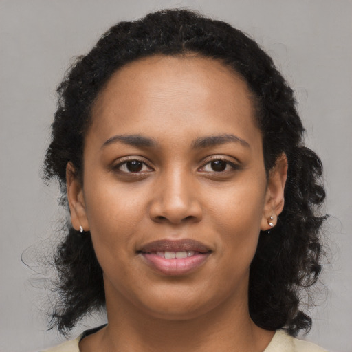 Joyful black young-adult female with long  black hair and brown eyes