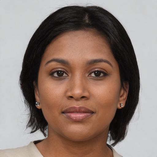 Joyful black young-adult female with medium  black hair and brown eyes
