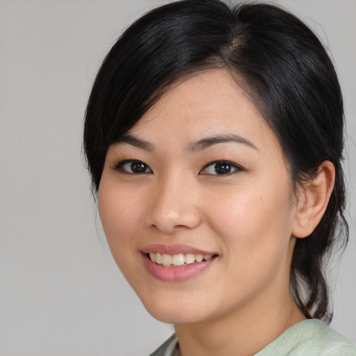 Joyful asian young-adult female with medium  black hair and brown eyes
