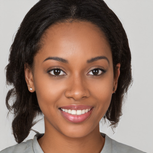 Joyful black young-adult female with medium  brown hair and brown eyes