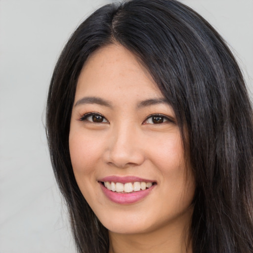 Joyful asian young-adult female with long  black hair and brown eyes