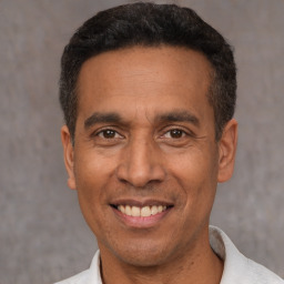 Joyful latino adult male with short  black hair and brown eyes