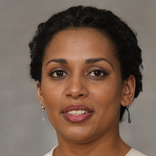 Joyful black adult female with short  brown hair and brown eyes