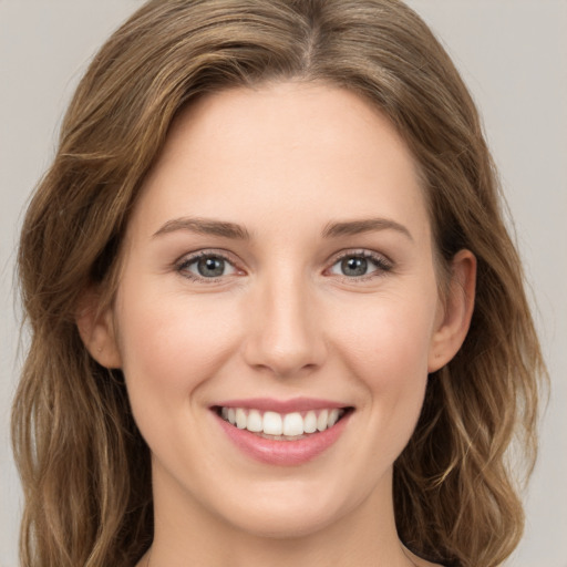 Joyful white young-adult female with long  brown hair and green eyes