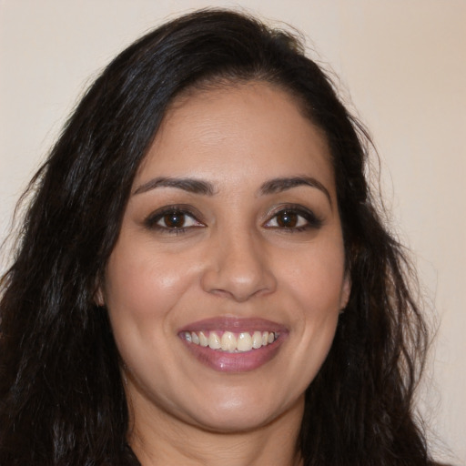 Joyful latino young-adult female with long  brown hair and brown eyes