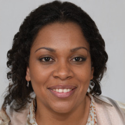 Joyful black adult female with medium  brown hair and brown eyes