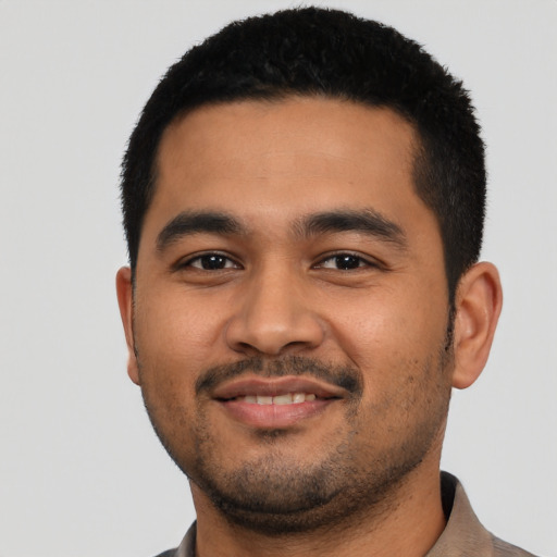 Joyful latino young-adult male with short  black hair and brown eyes